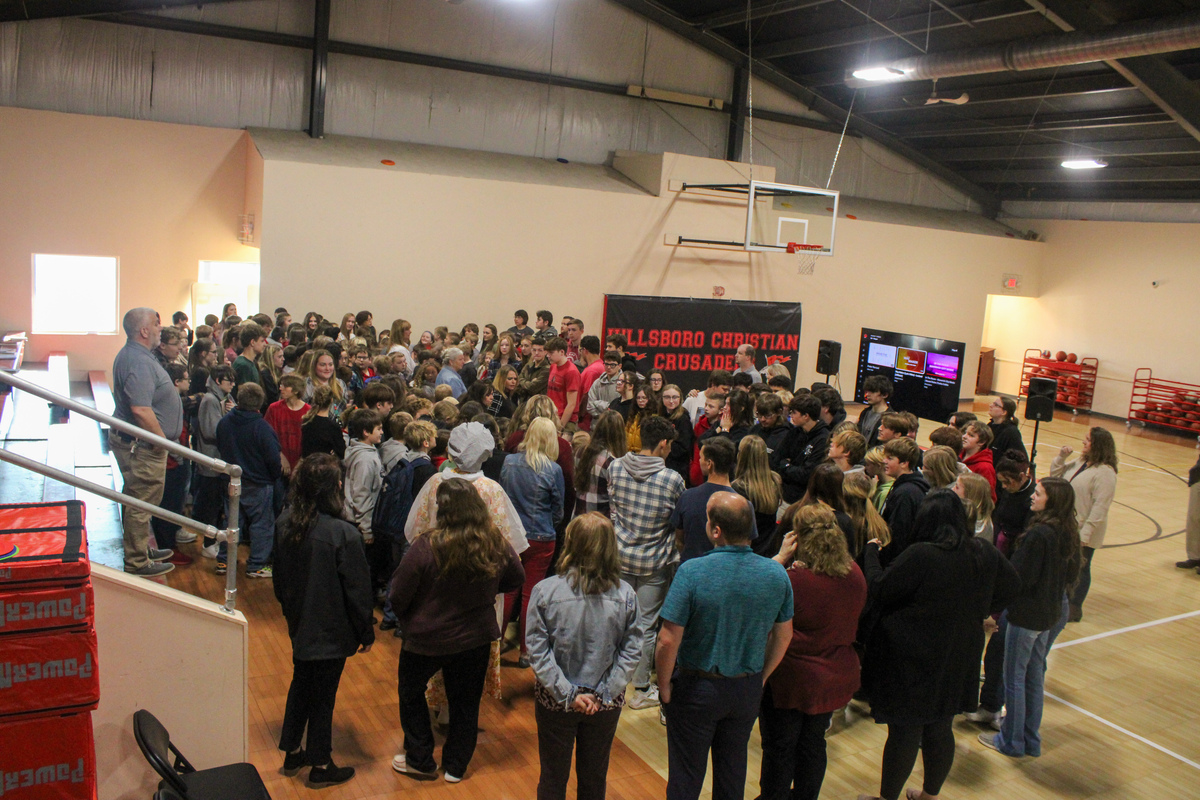 Students and staff praying over boxes